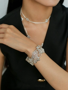 Detailed macro view of intricate silver floral lace hollow bracelet and matching necklace set