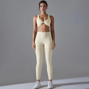 Two-piece yoga set in cream with crossover sports bra and high-waisted leggings