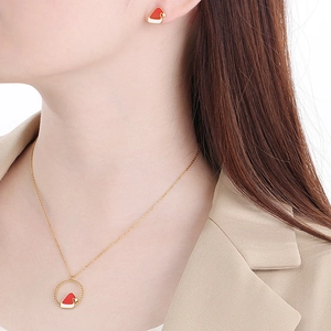 Festive gold necklace and earrings set with red and white Christmas hat pendants