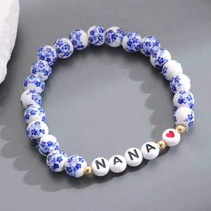 Dettaglio macro del bracciale in porcellana bianca e blu con lettere NANA e cuore rosso