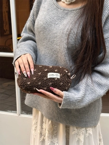 Detailed close-up of soft brown teddy plush pencil case with white polka dots