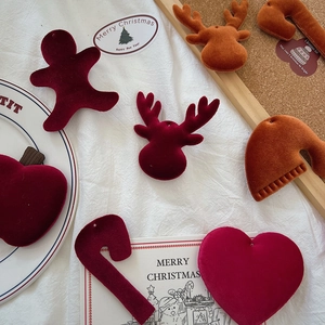 Detailed view of red and orange velvet Christmas ornaments like gingerbread man and elk