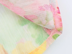 Detailed close-up of fine stitching and colorful floral poplin fabric texture