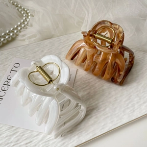Detailed view of ink-wash marble and tortoiseshell large claw clips with gold metal springs