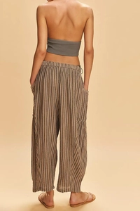 Detail view of brown striped wide-leg pants showing texture and side pocket design