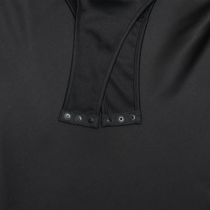 Detail view of smooth black bodysuit fabric with triple metal snap button closure