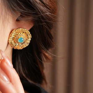 Detailed close-up of a vintage floral earring with blue stone and zircon inlay