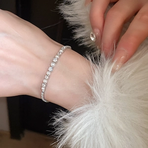 Detail of elegant silver bracelet with white pearls and zircon crystals on wrist