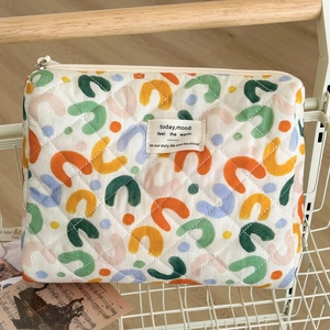 Quilted cotton makeup bag with colorful U-pattern in a white wire basket, soft texture