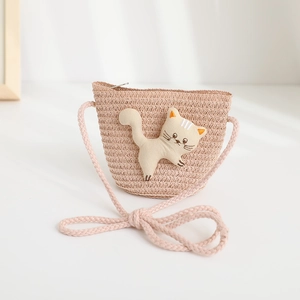 Detail of child straw crossbody bag with cute 3D cartoon kitten doll and woven strap