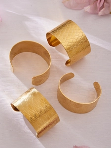 Gros plan détaillé de bracelets manchettes en acier inoxydable plaqué or 18 carats