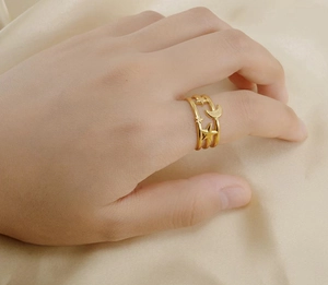 Detailed view of triple-layered 18K gold stainless steel moon and star ring on finger