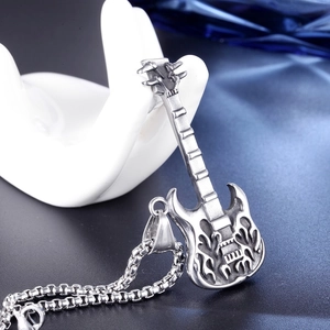 Detailed macro view of silver stainless steel electric guitar pendant with flame pattern