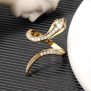Hip hop snake ring in gold metal featuring sparkling cubic zirconia on black background