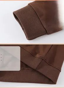 Detail of ribbed cuffs and hem stitching on brown cotton children dinosaur sweatshirt