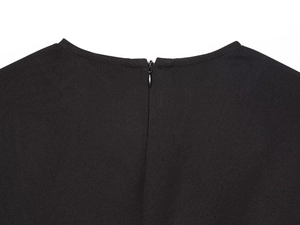 Gros plan de la robe midi noire montrant l'encolure dos et la fermeture éclair invisible