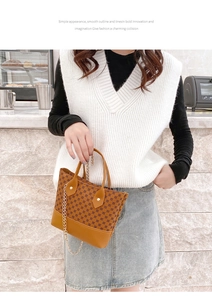 Detail of vintage patterned brown handbag with leather handle and gold chain strap
