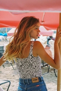 Detail van witte mouwloze top met zebraprint en rits achter en blauwe denim jeans