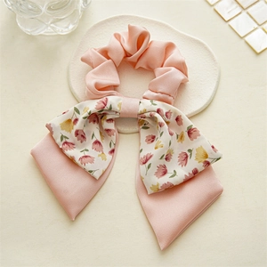Detail showing pink floral pattern and soft fabric texture of the double-layer bow scrunchie