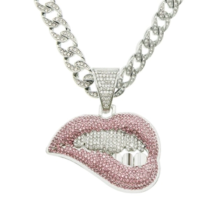 Macro shot of silver curb chain necklace with pink and white crystal lips pendant