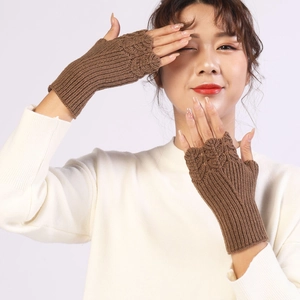 Detailed knit texture of brown fingerless winter gloves worn over white sleeves