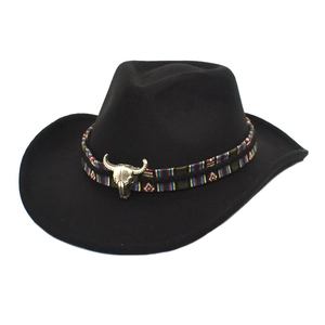 Detalle de sombrero vaquero negro con banda étnica y adorno de calavera de toro de metal