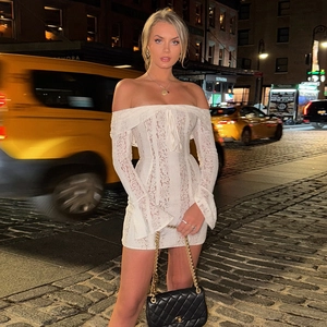 Sexy white lace off-shoulder mini dress with bell sleeves on an urban street background