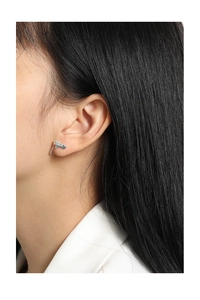 Close-up of minimalist silver irregular fluid metal earrings on model's ear