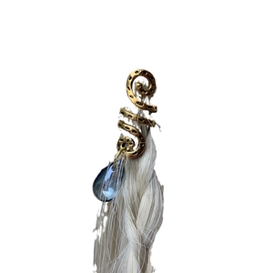 Golden spiral hair jewelry with a blue crystal drop pendant on light hair braid