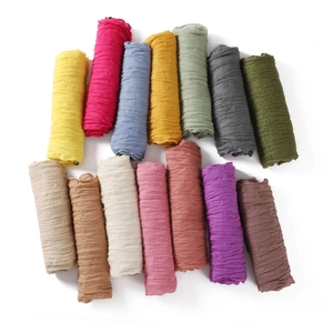 Close-up of multicolored wrinkled cotton-linen scarves displayed in 15 different vibrant hues