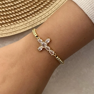 Elegant 18K gold plated cross bracelet with clear zircons worn on wrist by a model