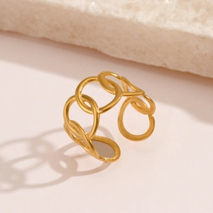Minimalist gold adjustable oval interlinked chain ring on a textured stone surface