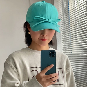 Detail shot of turquoise satin bow on lightweight breathable baseball cap for women