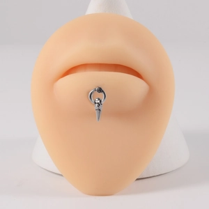 Detailed view of silver stainless steel lip ring with cone pendant on professional model