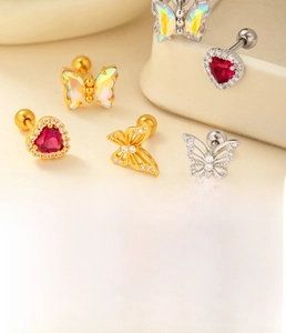 Macro detail of titanium steel heart and butterfly cartilage studs with zircon inlays