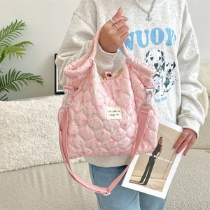 Détail du sac matelassé rose en coton avec motif lapin et étiquette de marque