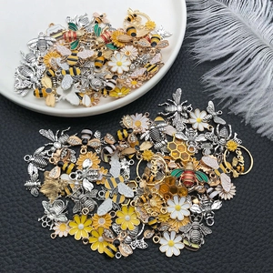 Detailed macro view of colorful enamel bee and flower metal charms on leather background