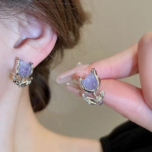 Detailed close-up of tulip-shaped silver earrings with lavender petals on a model