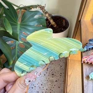 Detailed close-up of the green marble pattern acetate hair claw clip with glossy finish
