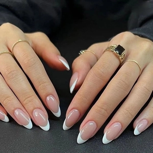French tip press-on nails with minimalist gold rings and black gemstone detail