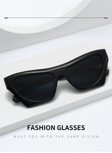 Modern black cat eye sunglasses displayed on minimalist white geometric stone blocks