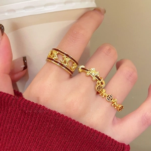 Detail of gold-plated rocking horse rings with red enamel worn in a cozy scene