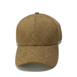 Vue détaillée d'une casquette beige avec motifs de marguerites brodées partout