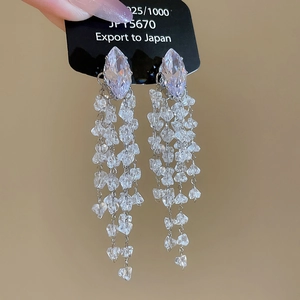 Close-up of elegant silver tassel earrings with marquise-cut crystals and dangling stones