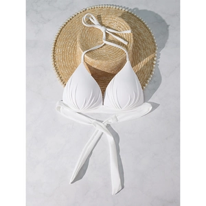 Detailed view of white halter bikini top with pleated cups on a pearl straw hat