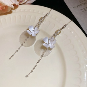 Detail of silver long drop earrings with matte flower and translucent shell discs