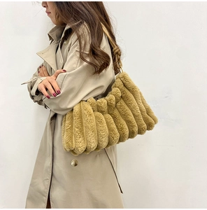 Close-up of brown plush handbag with pleated texture carried by a model in a beige coat