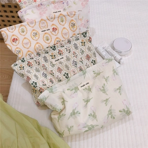 Detail of floral makeup bags in yellow and pink, showcasing soft cotton canvas texture