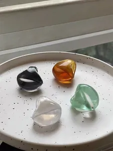 Detail of four colorful oval resin rings with pearlescent and transparent finishes