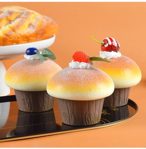 Macro shot of realistic PU artificial cupcakes with mixed berries on a black tray